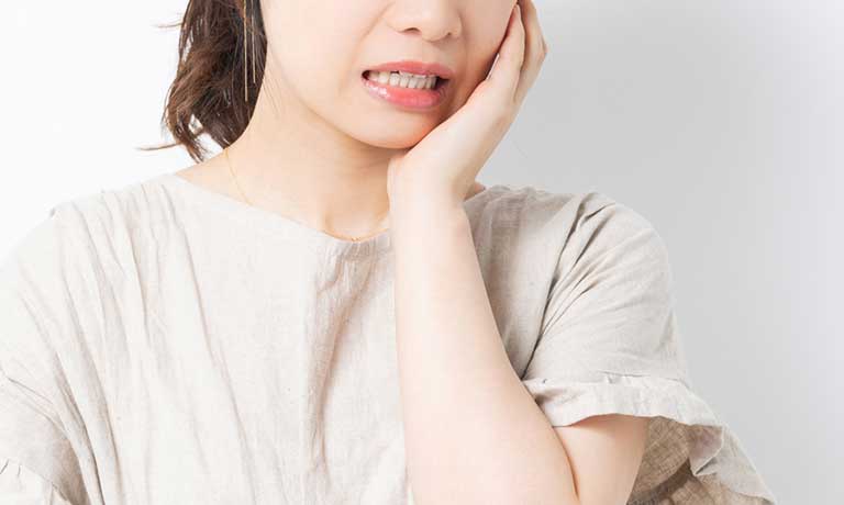 頬を押さえる女性