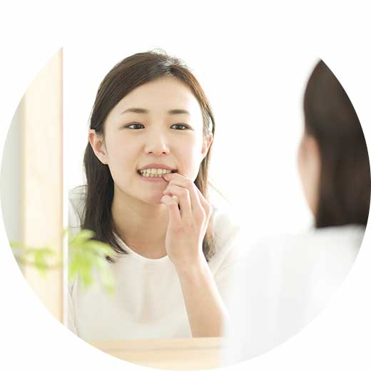 鏡で歯を見る女性