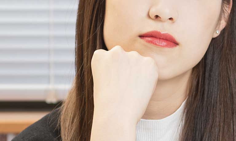 あごに手を当てる女性