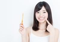 健康的な歯を指さす女性